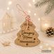 Adorno de Navidad personalizado de madera con forma de árbol, nombre de la familia Domínguez Moreno, mensaje de bienvenida y cordón para colgar.