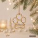 fotomontaje con fondo y ardonos navideños de la bola en tablex con forma de huella de perro y nombre Jara y cuerda de yute para colgar del árbol de navidad. 
