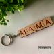 Llavero de madera de haya grabado al láser como si fueran letras de Scrabble, formando la palabra mamá, con anilla plateada