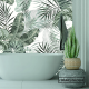 Imagen cuarto de baño en tonos verdes claro con el vinilo tropical con fondo blanco adornando la pared