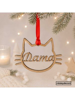imagen principal con fondo navideño de bola navideña en tablex para mascotas con silueta con forma de cara de gato personalizada con el nombre por dentro de la silueta y cinta roja para colgar del árbol de navidad.