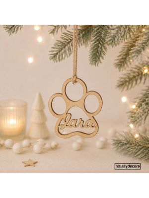 fotomontaje con fondo y adornos navideños de la bola en tablex con forma de huella de perro y nombre Jara y cuerda de yute para colgar del árbol de navidad. 