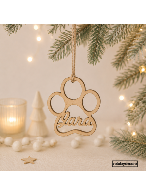 fotomontaje con fondo y ardonos navideños de la bola en tablex con forma de huella de perro y nombre Jara y cuerda de yute para colgar del árbol de navidad. 